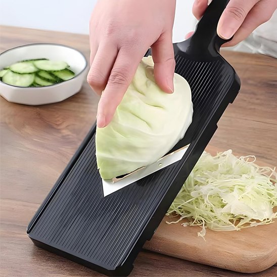Coupe legumes noir hachant chou sur planche en bois