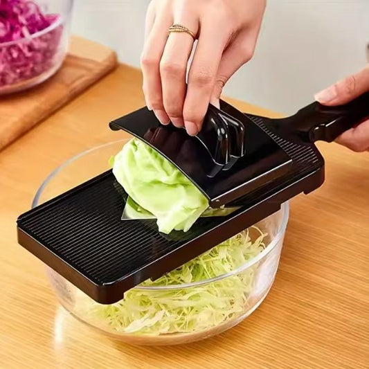Coupe legumes noir hachant concombre au dessus de bol en verre