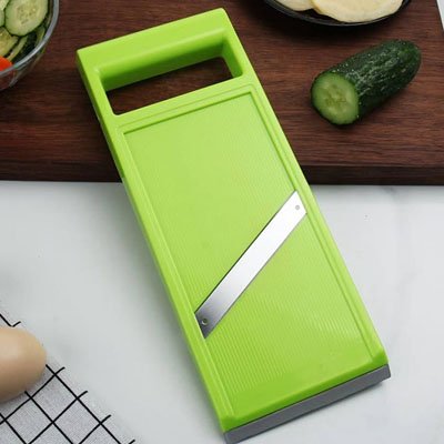 Cuisine Mandoline vert poser sur comptoir blanc avec planche a découper et concombre
