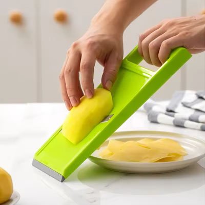 Cuisine Mandoline vert tranche pomme de terre au dessus  assiette blanche