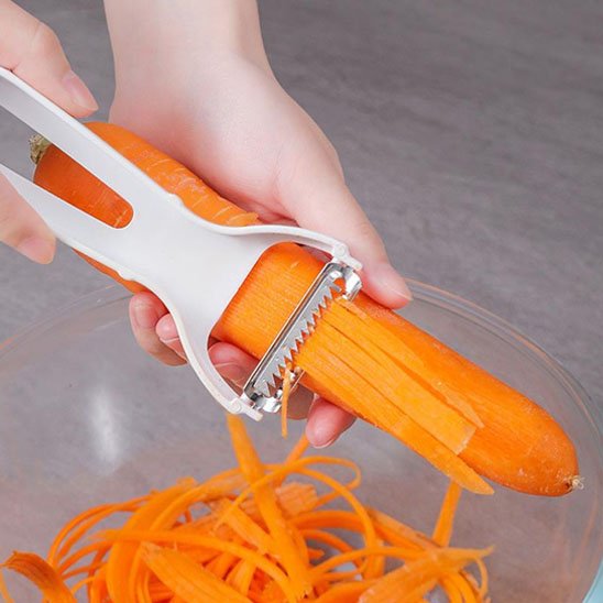 Econome blanc ergonomique épluchant carotte en julienne dans bol transparent