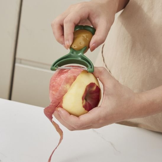 Éplucheuses à pommes de terre pelant pomme rouge