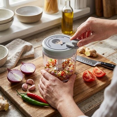 Hachoir mini contenant un mélange de légume haché utilisé à coté de tomate pient et oignon
