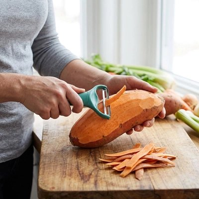 homme épluchant patate douce avec éplucheuse légumes ergonomique