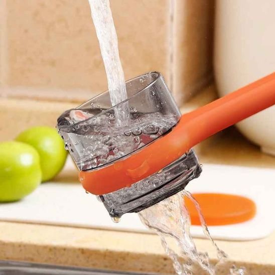 Nettoyage eplucheur legume orange sous l'eau du robinet