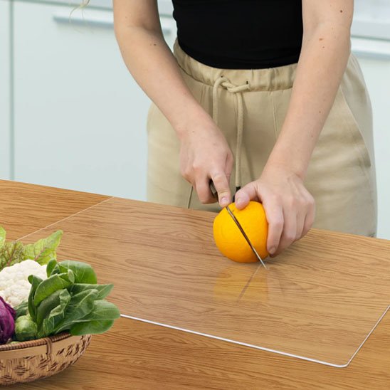 Planche à découper avec rebord poser sur table en bois pour couper orange